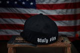 Black hat up against an American Flag backdrop. 