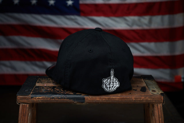 Backside of black hat with a skull style middle finger 